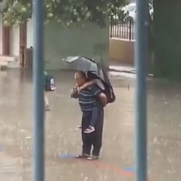 Yağmurda, sırtında torunu! İstiklal Marşı okudu